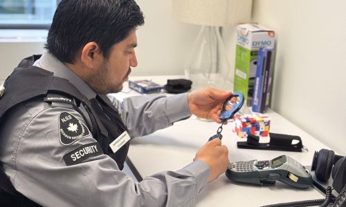 Nicagon security guard at a desk preparing his radio and patrol equipment before a shift