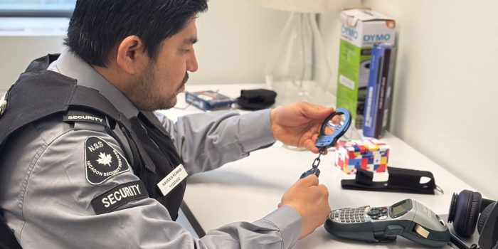 Nicagon security guard at a desk preparing his radio and patrol equipment before a shift